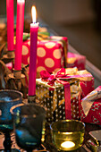 Bright pink candles and gift wrapped Christmas presents in East Dulwich home London UK