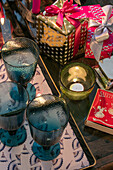 Blue glassware and tealight with wrapped Christmas presents in East Dulwich home London UK