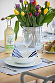Tulips and lemonade with place setting on dining table in Cornwall home UK