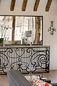 Large mirror above metalwork console with ornaments in Hampshire home UK