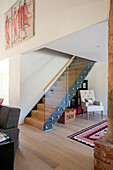 Wooden stairs with glass banister in open plan Hampshire home UK