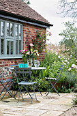 Folding chairs at table on terrace of Oxfordshire home UK