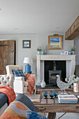 Orange blankets on furniture with marble fireplace in Oxfordshire living room UK