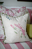 Embroidered cushion on striped sofa in London home UK
