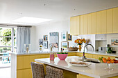 Gelbe offene Einbauküche mit Gartentüren in einem Londoner Haus, UK