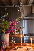 Mince pies and lit candles with flowers on oak worktop in Norfolk cottage England UK