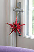 Roter Stern als Dekoration am Türgriff in einem Haus in Hampshire, Großbritannien