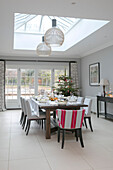 Dining table laid for Christmas dinner with tree in Hampshire extension UK