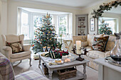 Weihnachtsbaum und Sessel in Erkerfenster mit Sofa und Tisch in Herefordshire Neubau UK