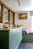 Green fitted units with timber frame in Kent cottage kitchen UK
