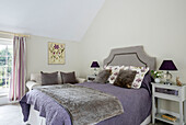 Grey blanket and cushions with purple lamps in Sussex bedroom UK