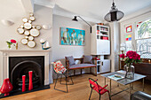 Mirrors above fireplace with red vases in London home UK