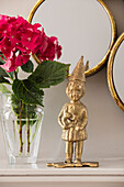 Goldenes Wichtelornament und Spiegel mit Schnittblumen in einem Londoner Haus UK