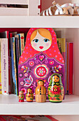 Russian dolls and books on shelving in London home UK