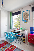 Desk and chair at window in child's room London UK