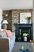 Cushions on sofa at fireplace with map in Grade II listed cottage Cornwall UK