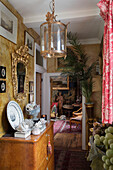 Vergoldete Laterne und Spiegel über einer hölzernen Anrichte im Flur eines Hauses in Sussex UJ