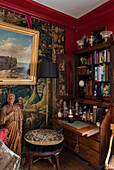 Bücherregal und Lampe aus Holz mit goldgerahmten Kunstwerken und Wandteppich in einem Haus in Sussex