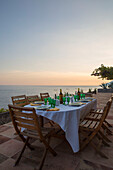 Gedeckter Tisch in der Abenddämmerung auf der Terrasse einer italienischen Villa an der Amalfiküste