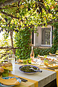 Green salad on table shaded by pergola in Italian villa on the Amalfi coast
