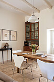 White pendant light and chairs at wooden table with botanic prints in Issigeac townhouse Perigord France