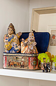 Two Indian figurines in old metal tin on shelf in Issigeac townhouse Perigord France