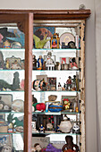Collection of figurines and ornaments in wall mounted cabinet Issigeac Perigord France