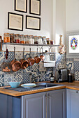 Kupfertöpfe hängen auf einem Regal mit getrockneten Lebensmitteln in Vorratsgläsern über der Spüle in einer Küche in Issigeac im Perigord Frankreich