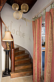 PInk and gold door curtains and wooden staircase with French wall stencil in Issigeac Perigord France