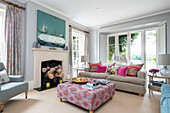 Living room with large windows furnished in pastel shades Hampshire home England UK