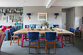 Blaue Stühle am Esstisch mit rosa lackierten Beinen in einem Haus in Hampshire England UK