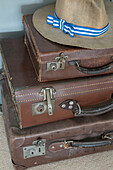 Sunhat on brown leather suitcases in Hampshire home England UK