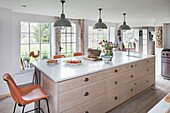 Pendant lights above limed oak kitchen drawers with retro barstools in Surrey kitchen UK