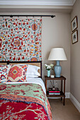 Doppelbett mit dekorativen handgefertigten Textilien in einer Wohnung im Norden Londons UK