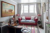 Red leather sofa and rocking horse in 1840s Cotswolds cottage Oxfordshire UK