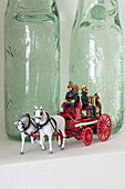 Vintage-Flaschen und Spielzeugkutsche mit Pferden in einem Cottage in den Cotswolds aus den 1840er Jahren, Oxfordshire UK