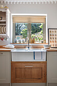 Belfast sink and plate rack in window of 1840s Cotswolds cottage Oxfordshire UK