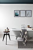 Framed prints above freestanding bath with ceiling painted Inchyra Blue in Cumbrian terrace UK
