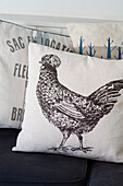 Hen cushion on bench seat in Wiltshire cottage UK