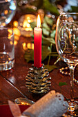 Lit candle and wineglass on table detail at Christmas in Norfolk farmhouse UK
