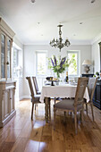 Wisteria in windows of dining room with wooden floor an dresser walls in Ammonite Surrey cottage UK