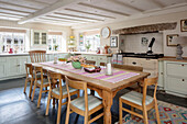 Holztisch und Stühle in einer großen Bauernhausküche mit Schränken in Asparagus Grade II listed Bodmin Cornwall UK
