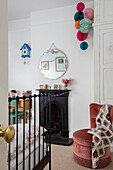 Crochet blanket on chair with antique mirror and metal framed bed in Derbyshire home UK