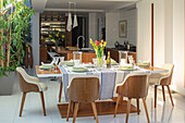 Retro style wooden chairs at table in large kitchen extension London UK