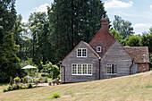 Weatherboard exterior and terrace of Surrey cottage in woodland UK