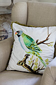 Parrot cushion on armchair in Surrey cottage UK