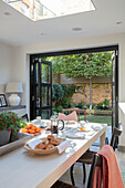 Modern dining area with doors opening to garden London UK