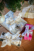 Eingepackte Weihnachtsgeschenke auf dem Holzboden unter dem Baum in Berkshire UK