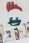 Family photos below retro laser cut signs 'Delicious' and 'Lucky' in West Sussex UK