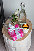 Water bottle and gift on treetrunk side table in 1960s country house West Sussex UK